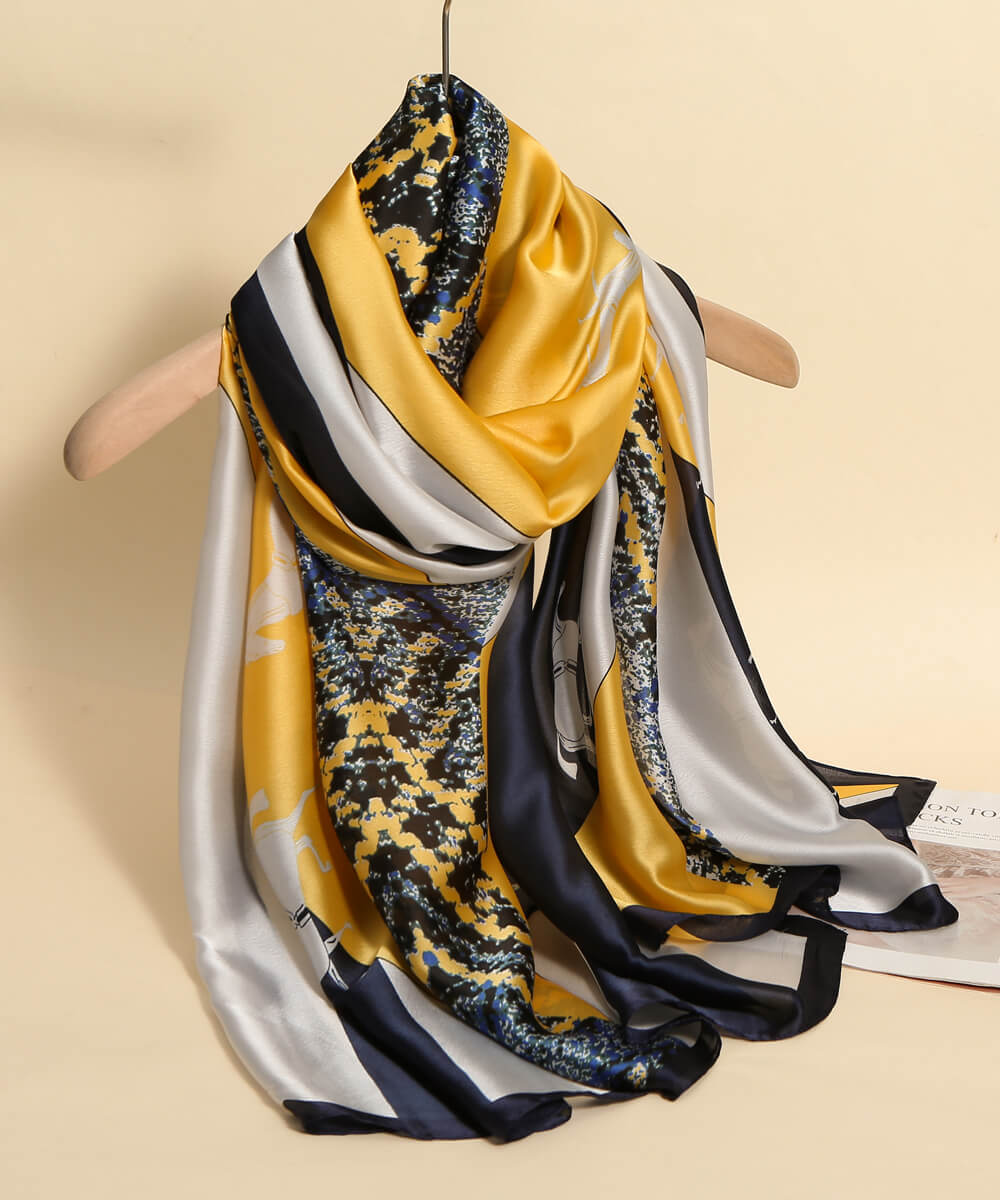 Mustard yellow, navy blue, and silver-grey silk-satin scarf featuring an abstract marbled pattern and bold geometric color blocks