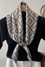 Slate blue and cream silk-satin scarf featuring a repeating interlocking Greek key geometric pattern